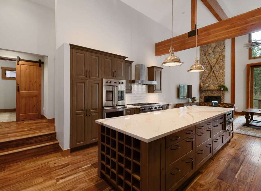 Experience luxury living in this stunning kitchen featuring a large island with a wine rack and ample storage.