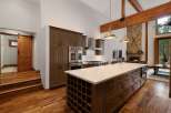 Experience luxury living in this stunning kitchen featuring a large island with a wine rack and ample storage.