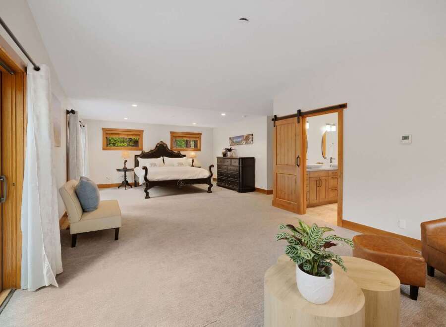 Experience luxury and comfort in this spacious master suite, featuring a grand king-sized bed with an ornate headboard and plush bedding.