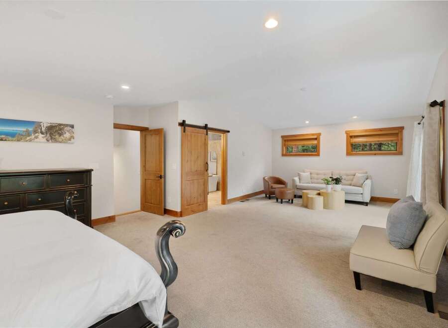 Experience luxury and comfort in this spacious master suite, featuring a cozy seating area perfect for relaxation.