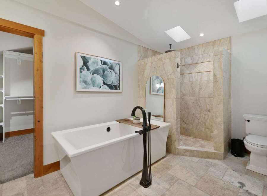 Indulge in luxury with this stunning bathroom featuring a freestanding soaking tub and a spacious walk-in shower with elegant tilework.