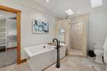 Indulge in luxury with this stunning bathroom featuring a freestanding soaking tub and a spacious walk-in shower with elegant tilework.