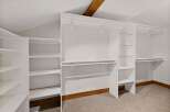 Discover ample storage in this spacious walk-in closet, featuring a versatile shelving system and multiple hanging rods.