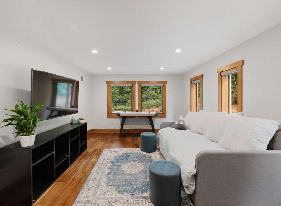 This cozy living room features a large flat-screen TV mounted above a sleek black media console, perfect for entertainment.