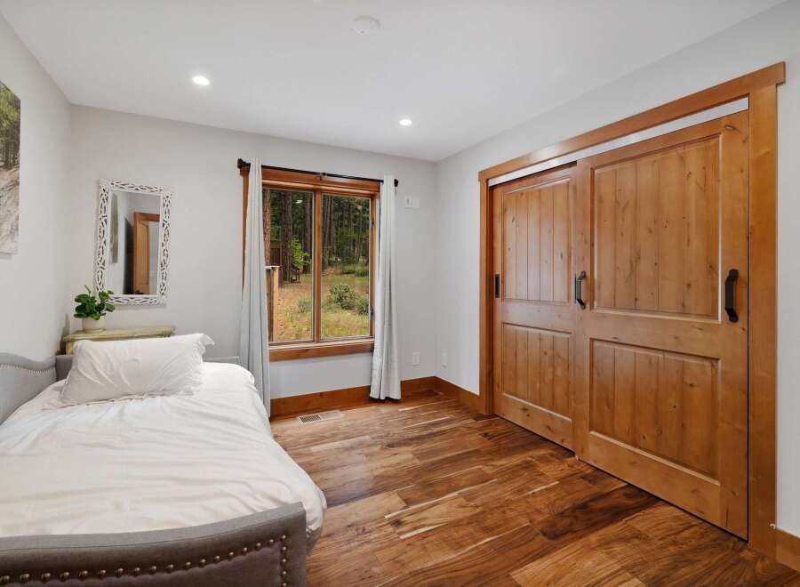Experience rustic charm in this bedroom featuring a cozy bed and a beautiful wooden sliding door.