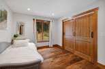 Experience rustic charm in this bedroom featuring a cozy bed and a beautiful wooden sliding door.