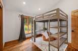 This bedroom features a space-saving loft bed with an integrated desk and shelving, perfect for maximizing room functionality.
