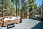 Enjoy ultimate relaxation on this spacious deck, featuring a luxurious hot tub perfect for unwinding amidst the serene forest setting.