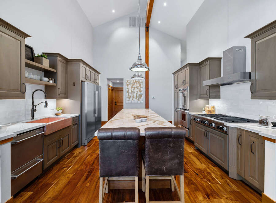 Experience luxury in this stunning gourmet kitchen, featuring a grand island with a marble countertop perfect for entertaining.
