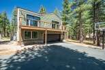 Experience modern mountain living in this stunning home, featuring a spacious deck perfect for enjoying the surrounding pine forest.