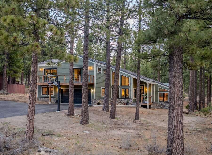 Nestled among tall pine trees, this modern home offers a serene mountain retreat.