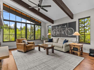 Experience breathtaking mountain views from this stunning living room, featuring a floor-to-ceiling stone fireplace and expansive windows that flood the space with natural light.