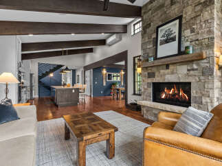 Experience rustic charm and modern comfort in this stunning living space, featuring a grand stone fireplace as the centerpiece.