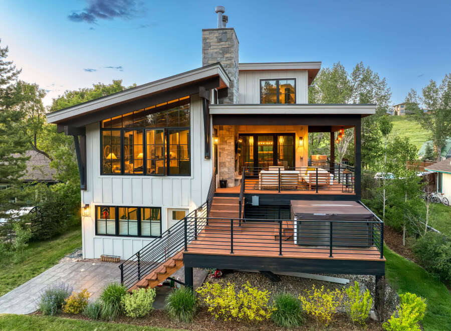 Experience modern mountain living in this stunning home featuring expansive windows and a multi-level deck perfect for entertaining.