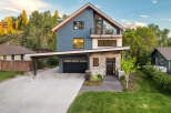 Experience modern mountain living in this stunning home featuring a striking blue exterior and a stone-clad entrance.