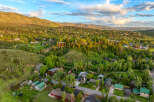 Nestled amidst lush greenery and rolling hills, this stunning aerial view showcases a charming neighborhood with a collection of beautiful homes.