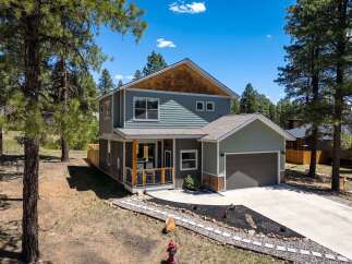 Discover this stunning modern home nestled amongst mature pine trees, offering a serene and private retreat.