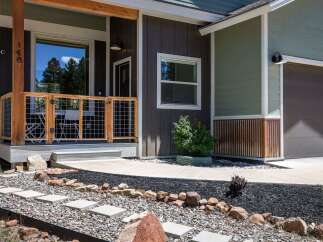 Discover this charming home featuring a welcoming porch with a rustic wooden and wire fence, perfect for enjoying the outdoors.