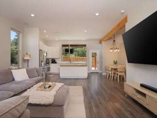 Experience modern living in this open-concept home featuring a spacious living area, a sleek kitchen with a central island, and a dining space perfect for entertaining.