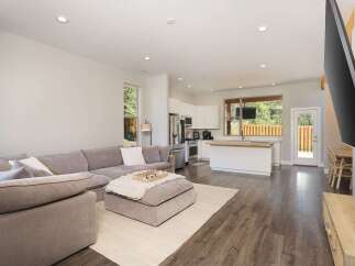 Experience modern living in this open-concept home featuring a spacious sectional sofa and a large ottoman perfect for gatherings.