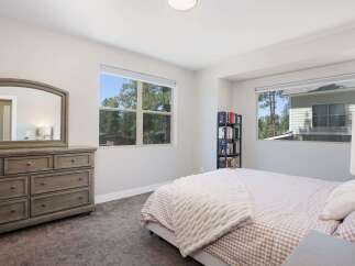 This inviting bedroom features a spacious dresser with an arched mirror, perfect for your morning routine.
