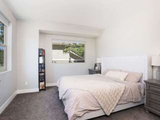 This inviting bedroom features a comfortable king-size bed with a charming gingham duvet and a cozy knit throw.