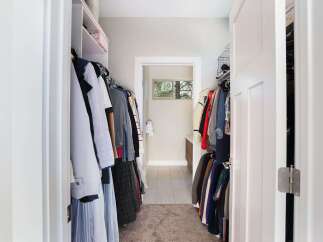 Step into this spacious walk-in closet, offering ample storage for your wardrobe with well-organized shelving and hanging racks.
