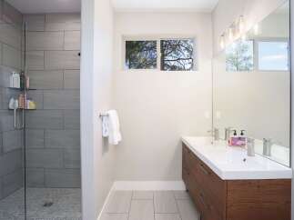 Experience modern luxury in this stunning bathroom featuring a spacious walk-in shower with elegant grey tilework and a sleek glass enclosure.