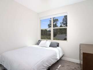 This cozy bedroom features a comfortable bed with crisp white linens and two plush pillows, perfect for a restful night's sleep.