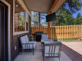 Enjoy outdoor living with this covered patio featuring comfortable seating and a built-in grill, perfect for entertaining.