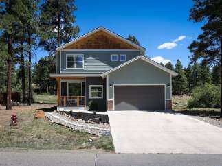 Discover this charming modern home nestled among tall pine trees, offering a serene and private retreat.