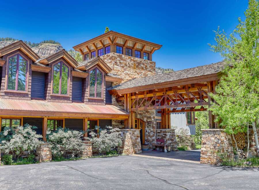 Experience luxury mountain living in this stunning custom-built home, featuring a striking stone and wood exterior that blends seamlessly with the natural landscape.
