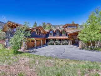 Experience luxury mountain living in this stunning custom-built home, featuring a striking stone and wood exterior that perfectly complements the natural surroundings.