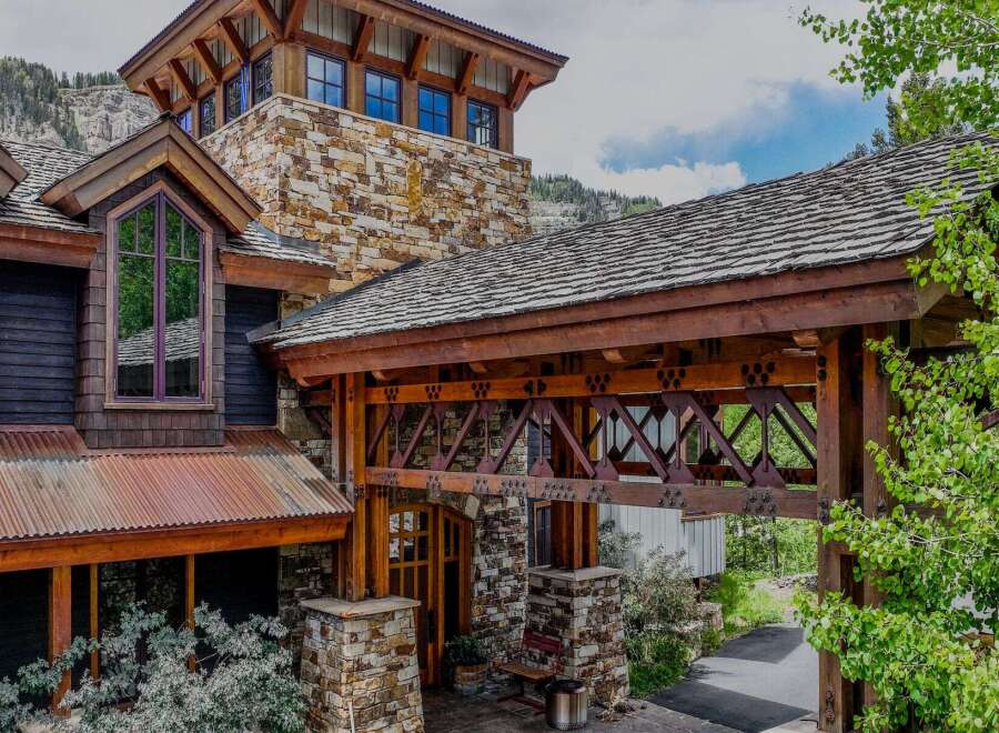 Experience rustic luxury in this stunning mountain home, featuring a unique stone and wood facade that blends seamlessly with the natural landscape.