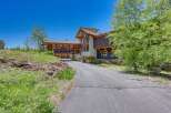Discover this stunning mountain home featuring a unique architectural design with natural wood accents and a grand covered entryway.
