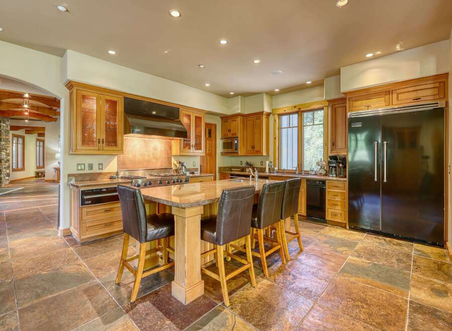 Experience luxury in this spacious kitchen featuring custom wood cabinetry and a large granite island perfect for entertaining.