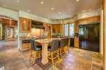 Experience luxury in this spacious kitchen featuring custom wood cabinetry and a large granite island perfect for entertaining.