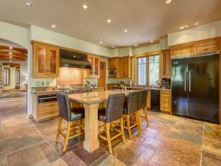 Experience luxury in this spacious kitchen featuring custom wood cabinetry and a large granite island perfect for entertaining.