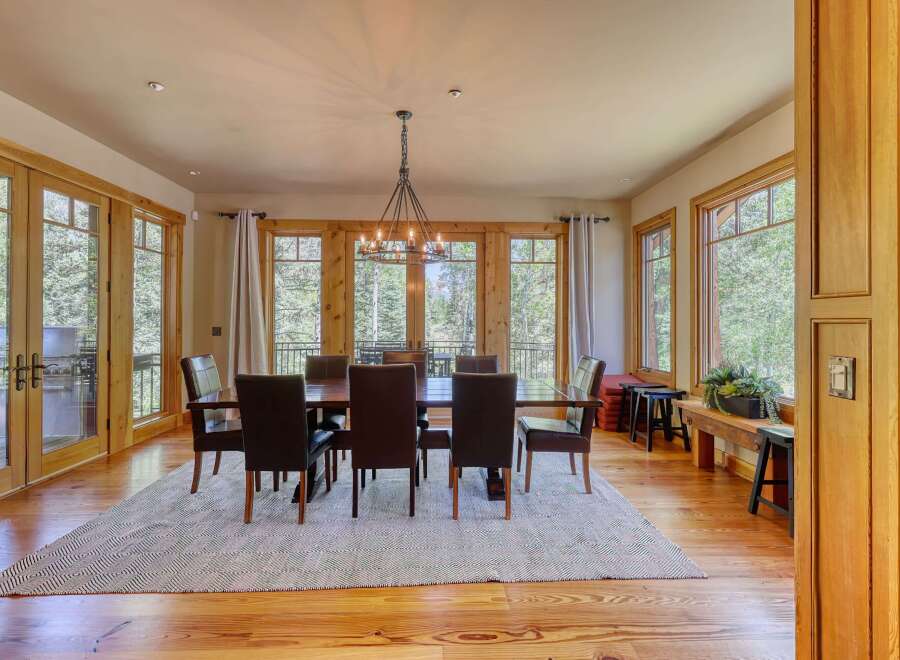 Experience elegant dining in this spacious room, featuring a large wooden table with plush leather chairs, perfect for hosting gatherings.