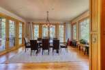 Experience elegant dining in this spacious room, featuring a large wooden table with plush leather chairs, perfect for hosting gatherings.
