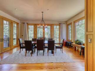 Experience elegant dining in this spacious room, featuring a large wooden table with plush leather chairs, perfect for hosting gatherings.