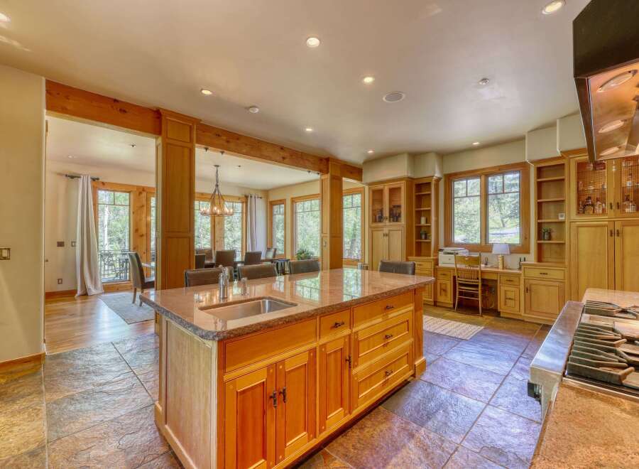 Experience luxury living in this stunning kitchen, featuring a large granite island with a built-in sink and ample cabinet space.