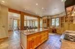 Experience luxury living in this stunning kitchen, featuring a large granite island with a built-in sink and ample cabinet space.