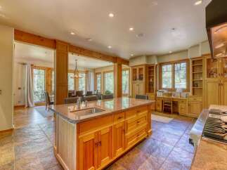 Experience luxury living in this stunning kitchen, featuring a large granite island with a built-in sink and ample cabinet space.