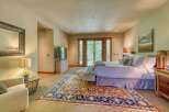 Experience ultimate comfort in this luxurious master bedroom, featuring a plush king-sized bed adorned with soft linens and a collection of decorative pillows.