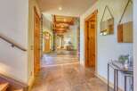Step into this grand entryway featuring stunning natural stone flooring and exposed wooden beams on the ceiling.
