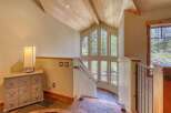 Ascend to new heights in this stunning home, featuring a dramatic vaulted ceiling with exposed wooden beams and recessed lighting.
