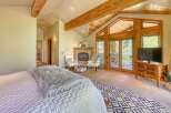 Experience luxury mountain living in this stunning bedroom featuring a cozy fireplace and direct access to a private balcony with scenic views.