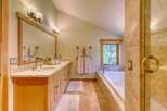 Experience luxury in this stunning bathroom featuring a spacious double vanity with granite countertops and elegant mosaic tile backsplash.