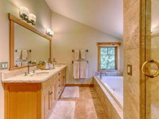 Experience luxury in this stunning bathroom featuring a spacious double vanity with granite countertops and elegant mosaic tile backsplash.